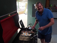 Greg fries up some bacon and eggs for breakfast in the Hilton
